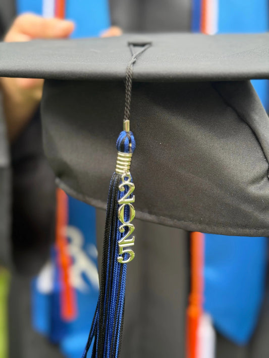 Black graduation cap with 2025 tassel, blue and orange graduation stole in background