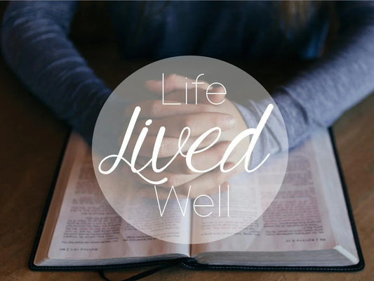 Hands clasped over open Bible with text Life Lived Well, faith inspiration image