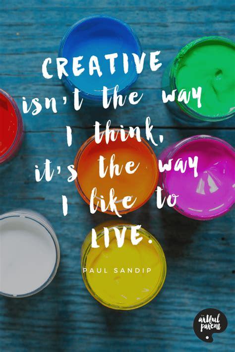 Colorful paint jars with inspirational creative quote overlay, art supplies flat lay.