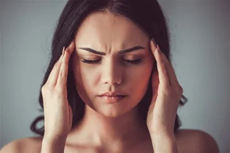 Woman with headache holding temples, stress and pain relief concept