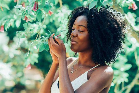 Woman enjoying flowers outdoors, summer garden, nature, peaceful moment, floral background
